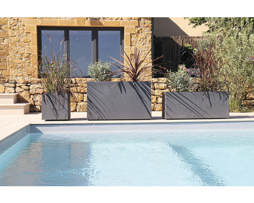 Tri osadené kvetináče rôznych veľkostí vedľa bazéna.