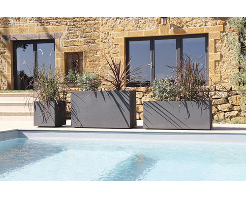 Tri sivé kvetináče rôznych veľkostí pri bazéne