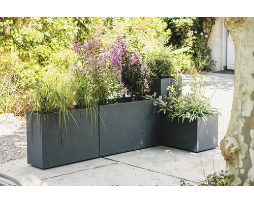 Kovové kvetináče s rôznymi rastlinami vonku