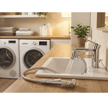 Svetlá kúpeľňa s umývadlom, batériou so sprchovou hadicou a práčkami