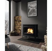 Obývacia izba s krbovými kachlami, hromadou palivového dreva a čiernobielou fotografiou