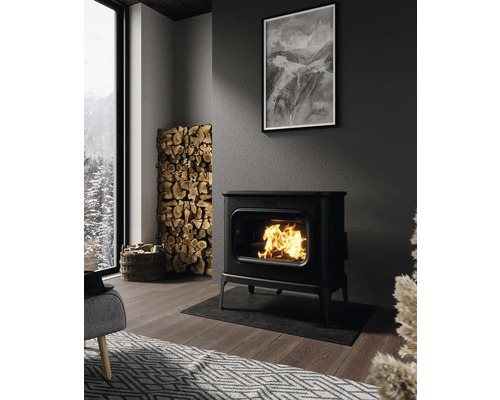 Obývacia izba s krbovými kachlami, hromadou palivového dreva a čiernobielou fotografiou