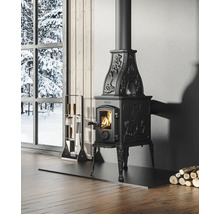 Čierna pec v miestnosti s krbovým náradím a polenami