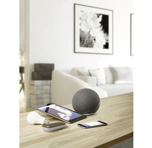 Snímka obývačky s inteligentnými domácimi zariadeniami, ako sú reproduktory, tablety, smartfóny a žiarovky na stole.