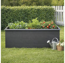 Vyvýšený záhon so zeleninou, krhlou a košíkom s kvetmi v záhrade.