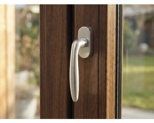 Detail hnedého okna so striebornou kľučkou