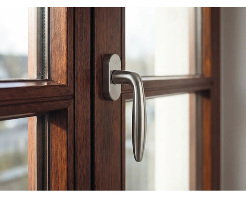 Detail okna s dreveným rámom a kľučkou