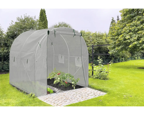 Tunelový skleník v záhrade s rastlinami paradajok