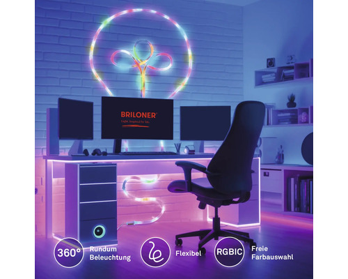 Flexibilný RGBIC LED pásik ako dekoratívne 360 stupňové osvetlenie na stene a stole v pracovni s počítačom. Briloner Logo.