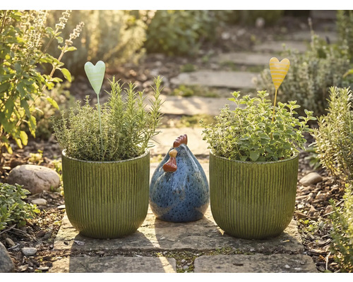 Záhradné zátišie s vysadenými kvetináčmi, kolíky v tvare srdca a ozdobnou sliepkou na kamennej ceste