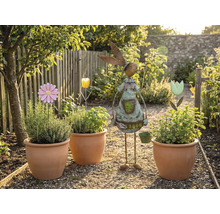 Záhradná scéna s osadenými terakotovými kvetináčmi, kvetinovými zápichmi a záhradnou dekoráciou v tvare zajaca