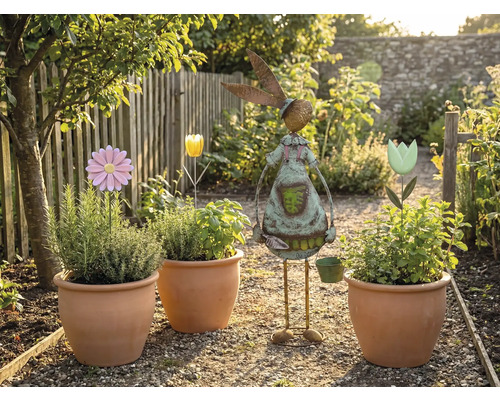 Záhradná scéna s osadenými terakotovými kvetináčmi, kvetinovými zápichmi a záhradnou dekoráciou v tvare zajaca