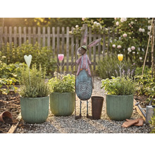 Záhradná scéna s osadenými kvetináčmi, kovovým zajacom a dekoráciami na štrkovej ceste