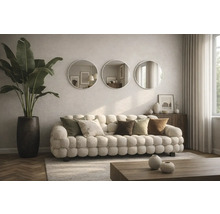 Obývacia izba s pohovkou, vankúšmi, okrúhlymi zrkadlami a izbovou rastlinou