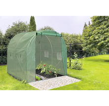 Zelený fóliový skleník s otvorenými dverami na dláždenej ploche v záhrade.