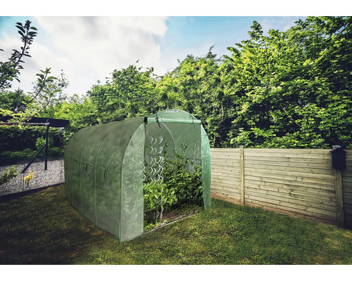 Záhradný skleník s rastlinami v záhrade