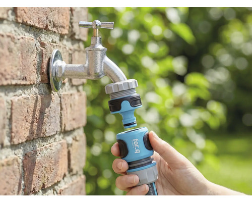 Záhradná scéna s vodovodným kohútikom, ku ktorému je v ruke pripojený konektor záhradnej hadice for_q