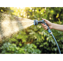 Ruka drží záhradnú hadicu s rozprašovacou hlavicou
