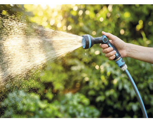 Ruka drží záhradnú hadicu s rozprašovacou hlavicou