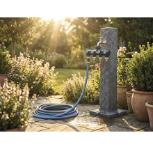Záhradná scéna s vodným stĺpikom, rozdeľovačom a záhradnou hadicou na kamennej terase