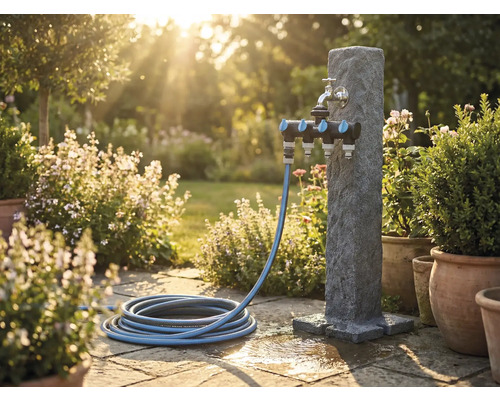 Záhradná scéna s vodným stĺpikom, rozdeľovačom a záhradnou hadicou na kamennej terase