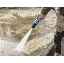 Osoba čistí kamennú terasu záhradnou hadicou for_q