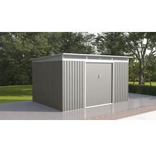 Moderný kovový záhradný domček s dvojkrídlovými dverami a plochou strechou na dláždenej terase v záhrade so stromami.