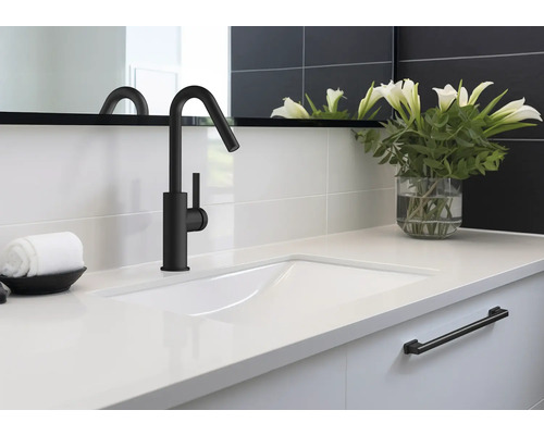 Umývadlo s čiernou batériou, uterákom a vázou s kvetinami v kúpeľni