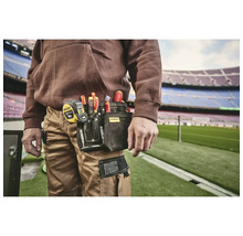 Remeselník s puzdrom na náradie na opasku, plným skrutkovačov a zvinovacieho metra od spoločnosti Stanley