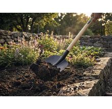 Lopata dvíha zeminu v záhone.