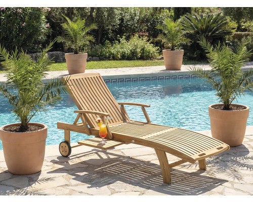 Scéna s dreveným lehátkom, kokteilom a rastlinami pri bazéne.