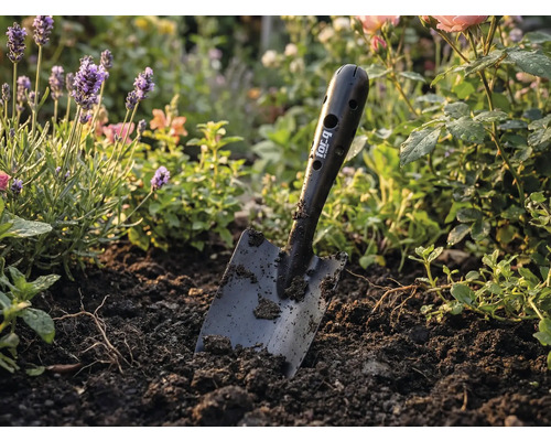 Záhradný rýľ for_q v záhone s kvetmi