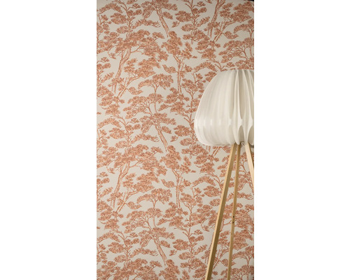 Tapeta so vzorom borovíc v pozadí, v popredí moderná stojaca lampa s plisovaným tienidlom a drevenými nohami.