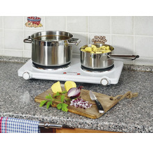 Dvojitá varná doska s dvoma nerezovými hrncami a ingredienciami na doske na krájanie