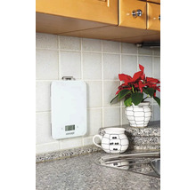 Biela digitálna kuchynská váha na obkladanej kuchynskej stene