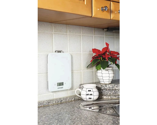 Biela digitálna kuchynská váha na obkladanej kuchynskej stene