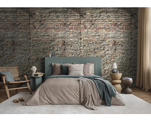 Spálňa s tehlovou stenou, posteľou, stoličkou a príručnými stolíkmi pre útulnú atmosféru.