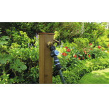 Záhradná scéna s vodovodným kohútikom, rozdeľovačom a hadicou na drevenom stĺpiku