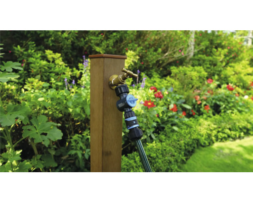 Záhradná scéna s vodovodným kohútikom, rozdeľovačom a hadicou na drevenom stĺpiku