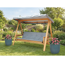 Drevená hojdačka so sivými podložkami a strieškou v záhrade