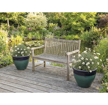 Záhradná scéna s drevenou lavicou, jazierkom a kvetinami v kvetináčoch na drevenej terase