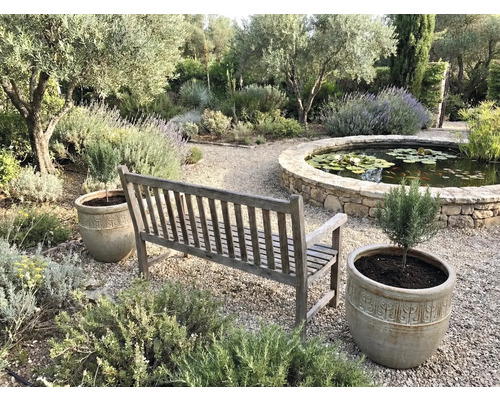 Záhradná scéna s drevenou lavičkou, kvetináčmi a jazierkom