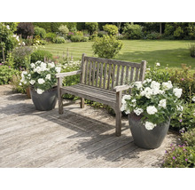 Záhradná scéna s drevenou lavicou a kvetináčmi na drevenej terase