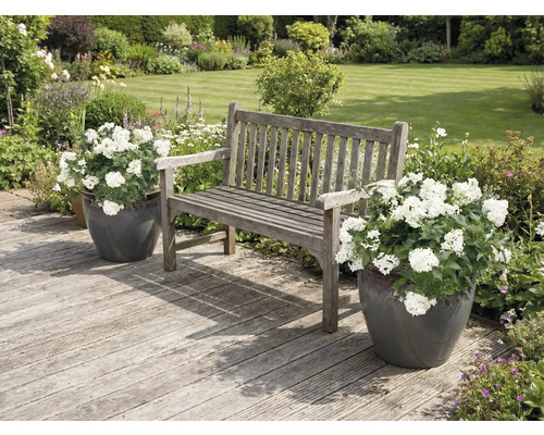 Záhradná scéna s drevenou lavicou a kvetináčmi na drevenej terase