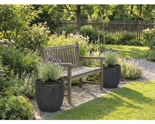 Záhradná krajina s drevenou lavicou a rastlinami v štruktúrovaných kvetináčoch