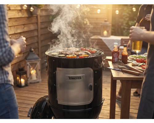 Údiaci gril s mäsom a zeleninou na grilovacej mriežke na záhradnej grilovačke.