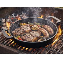 Grilovacia panvica so steakmi, klobásami a zeleninou na grile