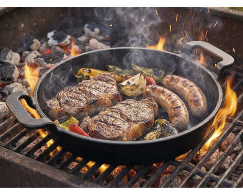 Grilovacia panvica so steakmi, klobásami a zeleninou na grile