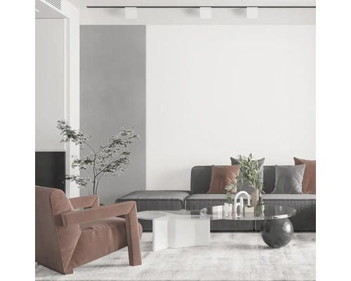 Moderná obývacia izba so sivou pohovkou, kreslom a konferenčnými stolíkmi