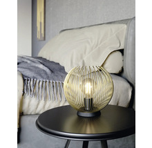 Zlatá drôtená guľová lampa na stole v spálni